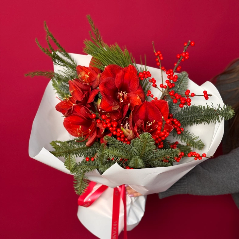 Яркий букет с алыми амариллисами и хвоей