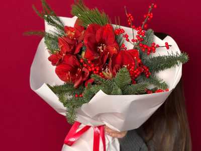 Яркий букет с алыми амариллисами и хвоей