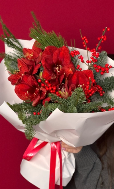 Яркий букет с алыми амариллисами и хвоей